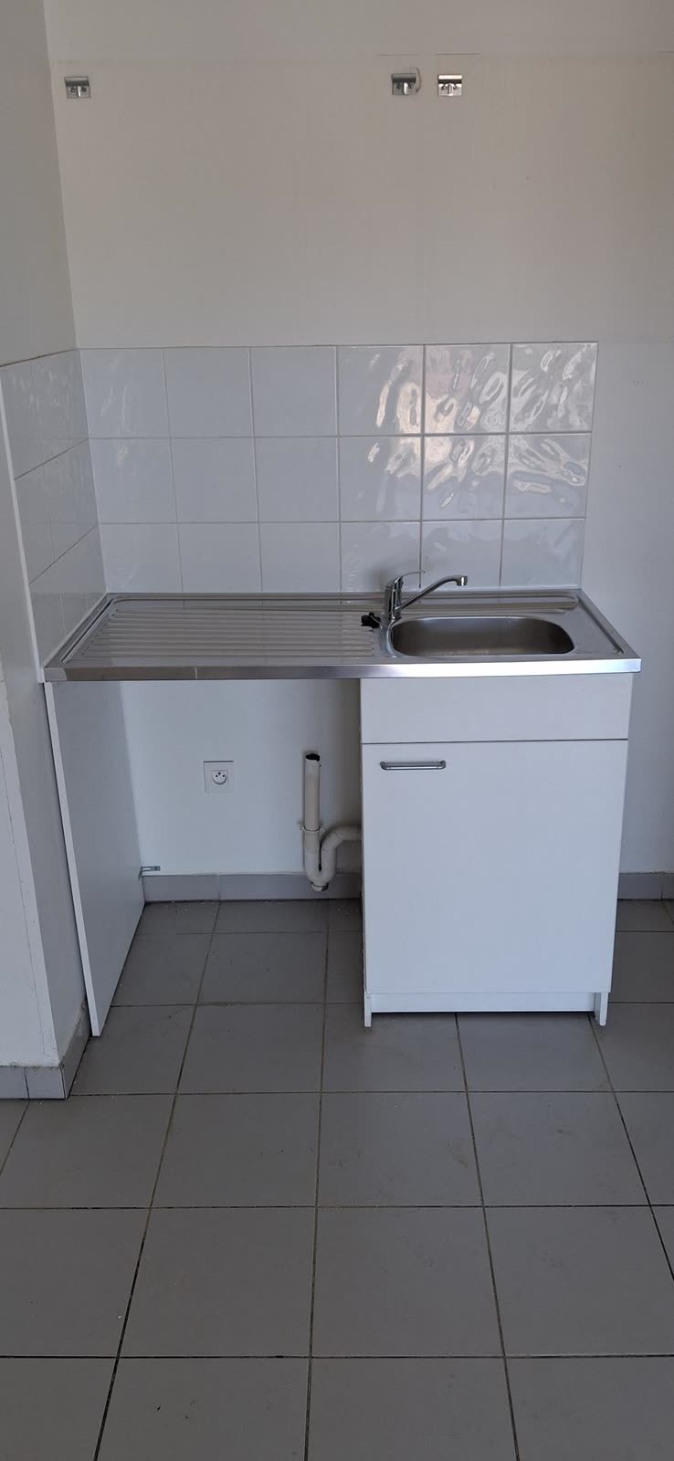 Évier et robinet installés dans une cuisine équipée